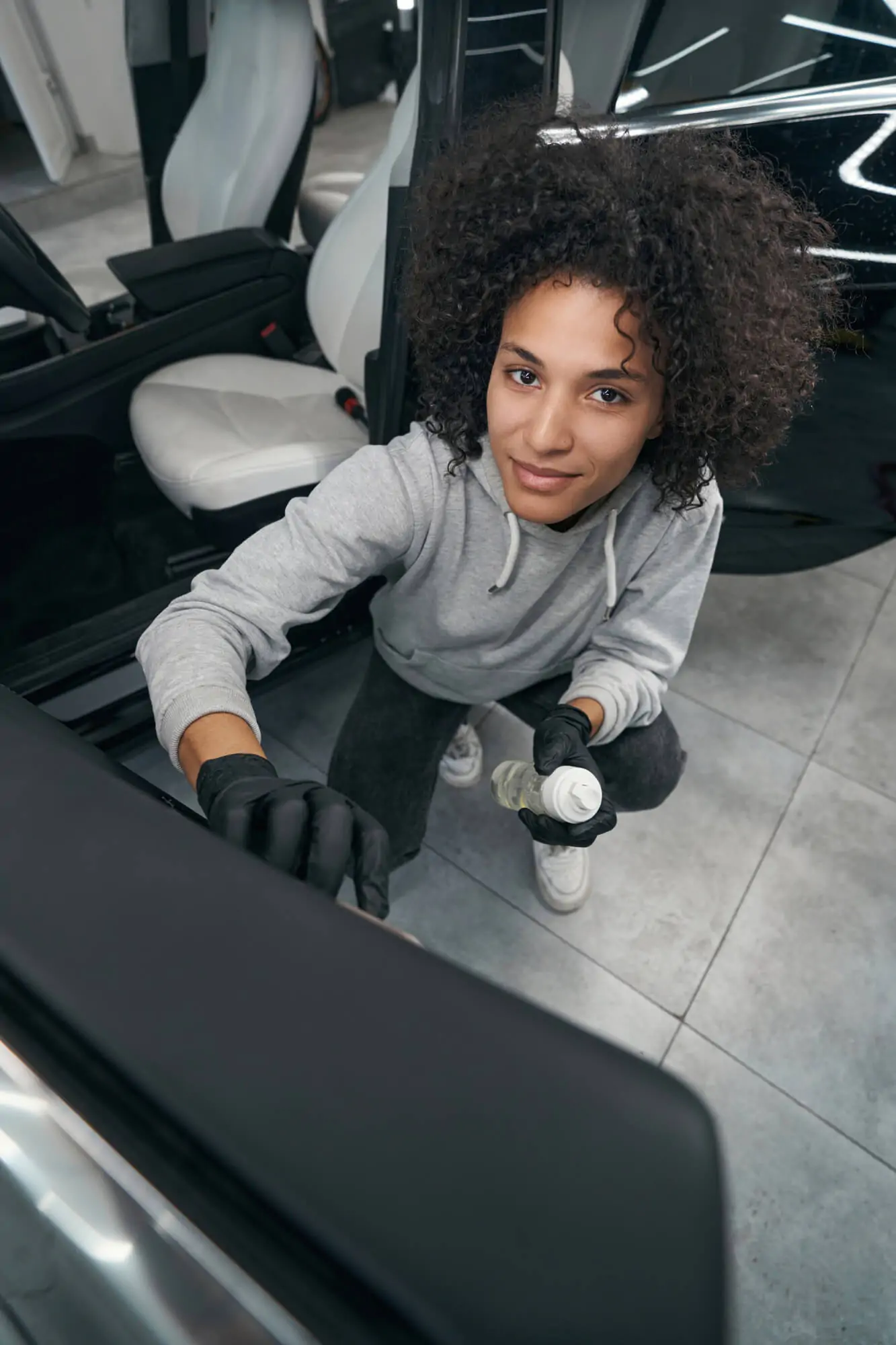 pleased auto detailer brushing car door panel